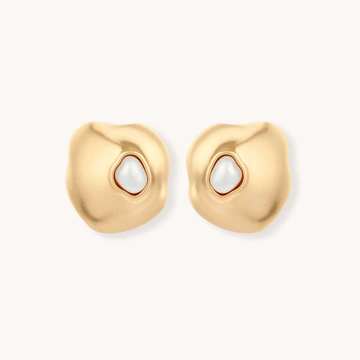 Gold organic-shaped stud earrings with white pearl centers and flowing curves on neutral background.