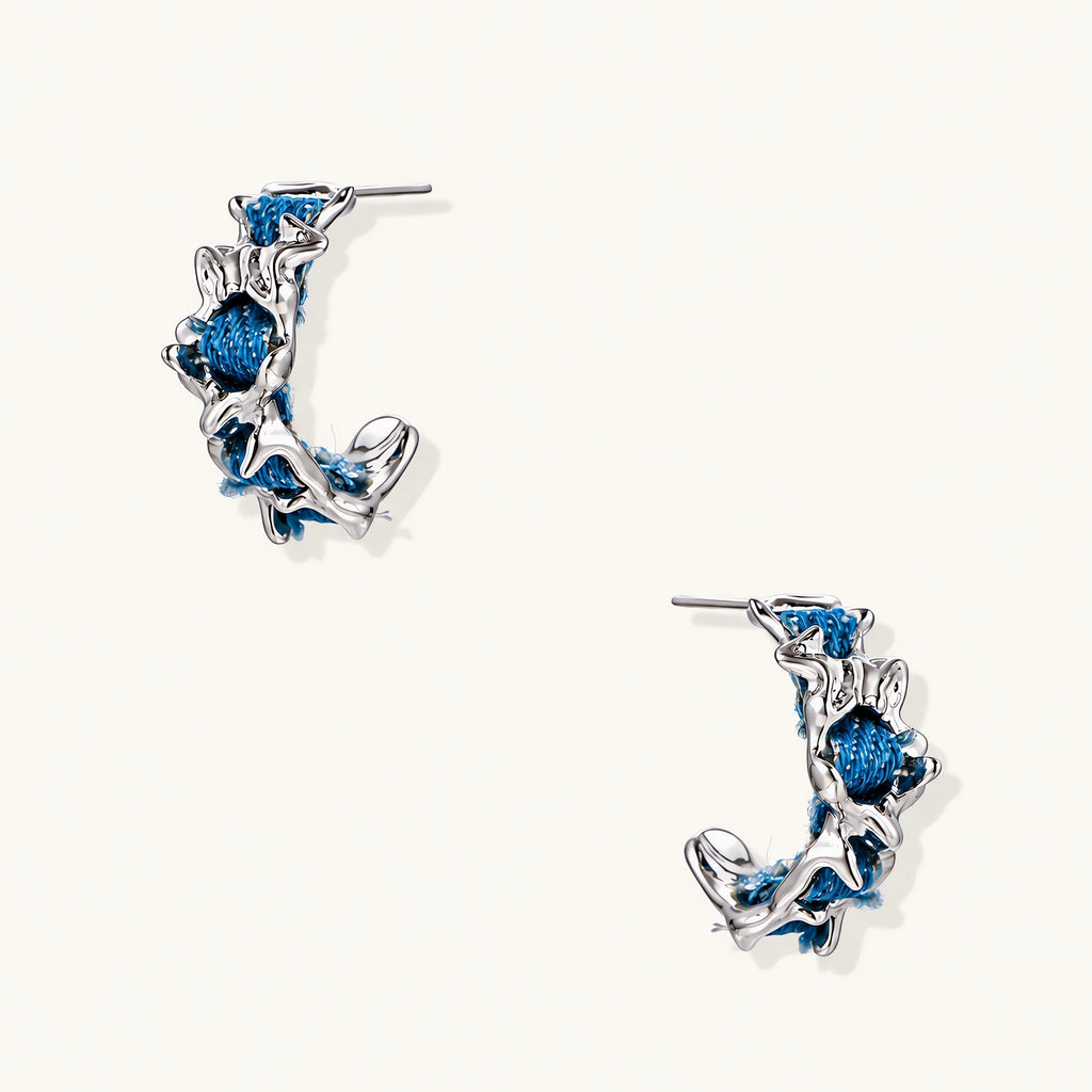 White gold plated hoop earrings with woven blue denim fabric through organic branch-like metal framework