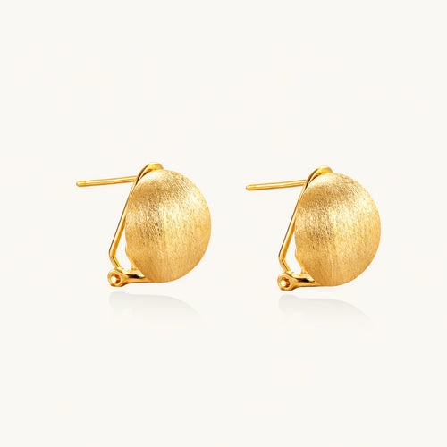 Pair of brushed gold dome earrings with clip backs showing textured matte finish on cream background