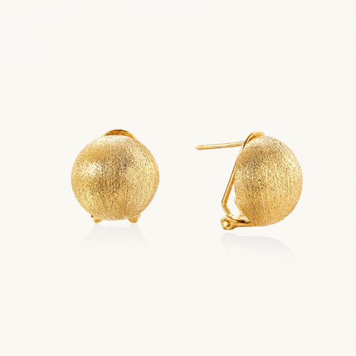 Pair of brushed gold dome earrings with clip backs showing textured matte finish on cream background