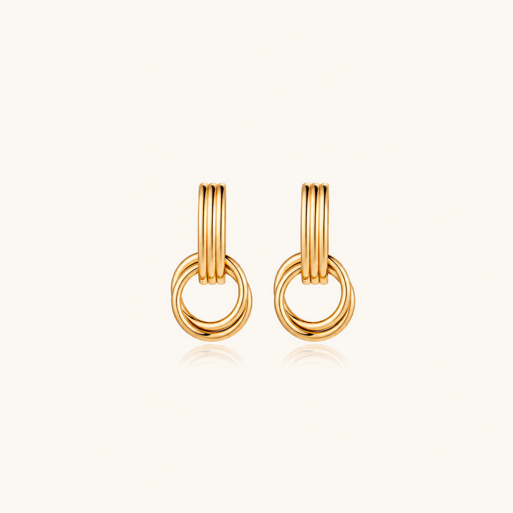 Gold stud earrings with vertical ridged bar connecting to triple interlocking circular rings on white background