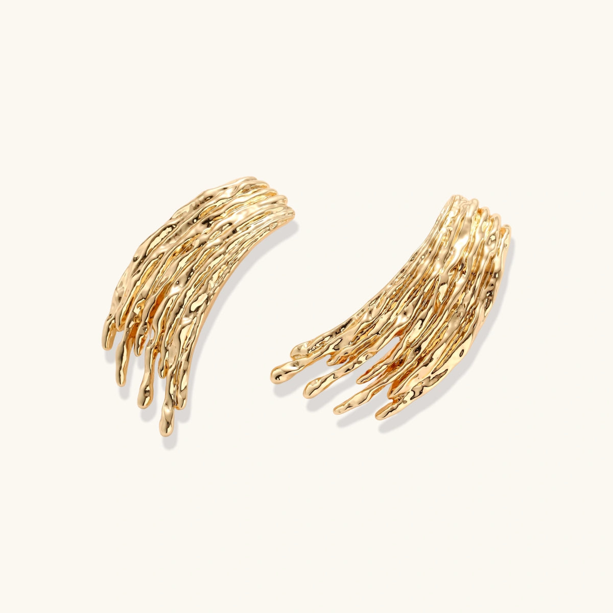 Gold-toned statement earrings with cascading liquid metal-inspired strands on white background.